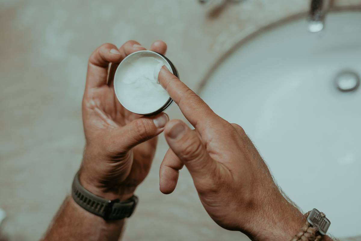 Woman applying fragrance scented lotion how to put on forearm with palms smoothing evenly